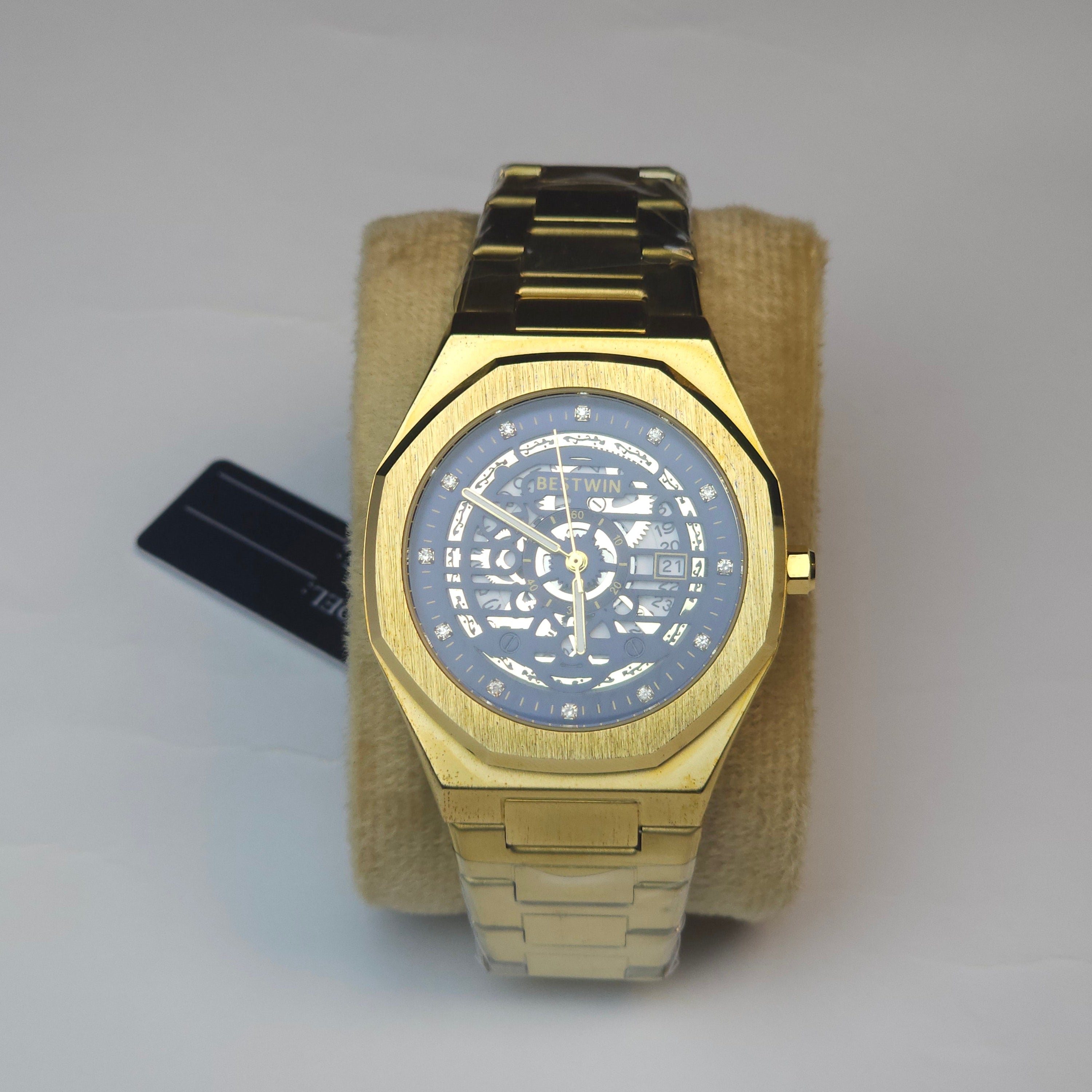 Gold wristwatch with a detailed face on a light gray background
